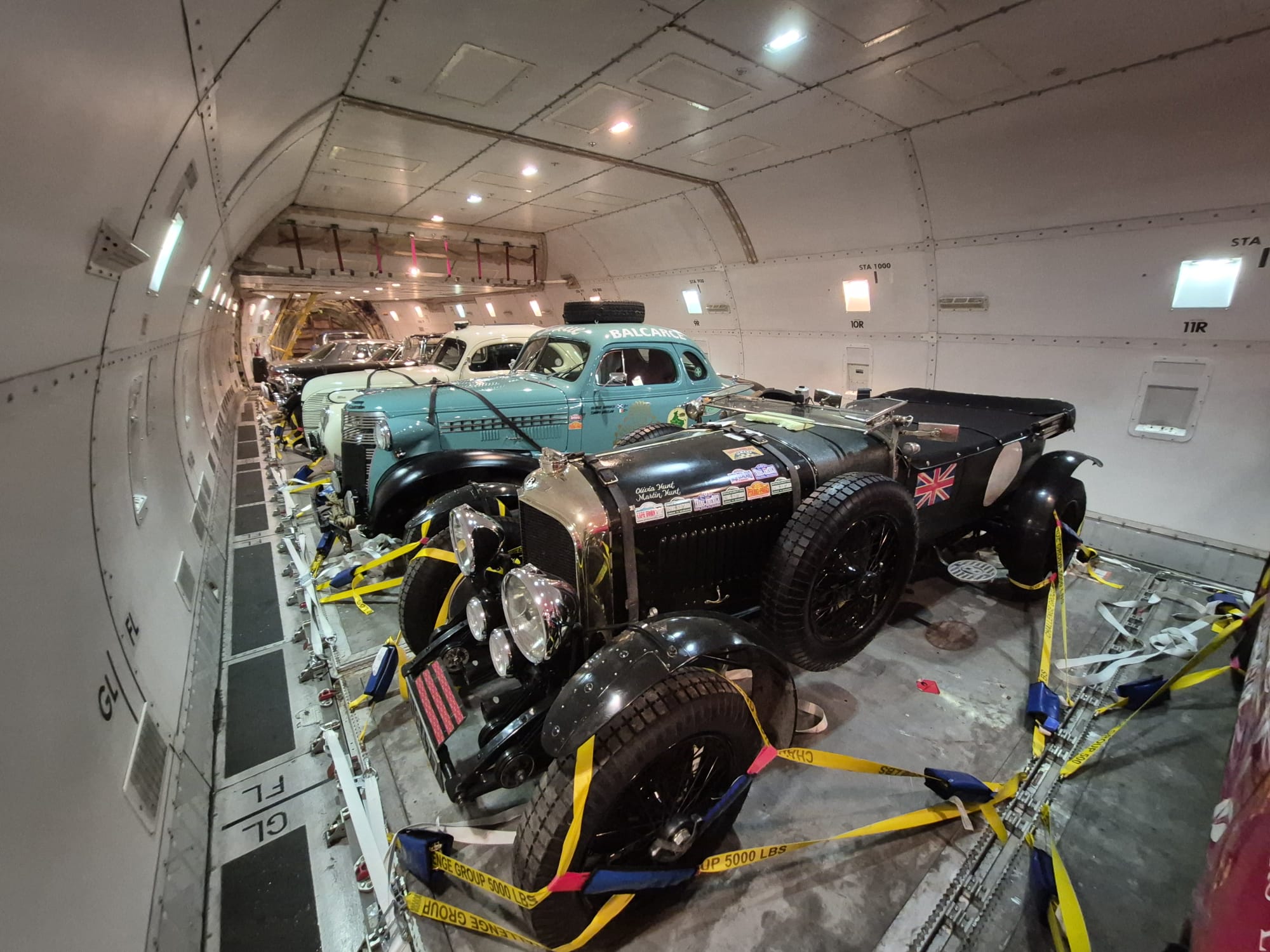 Vintage classic cars strapped down inside a freighter main deck